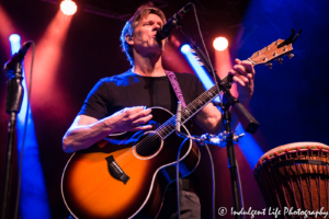 Kevin Bacon playing the acoustic guitar at the Voodoo Lounge concert venue inside of Harrah's Casino in Kansas City, MO on July 14, 2018.