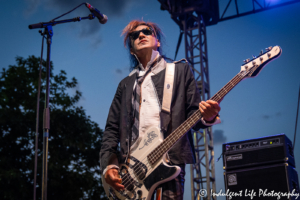 Bass guitarist Pando of A Flock of Seagulls in a live festival performance at Town Center Plaza's Sunset Music Fest in Leawood, KS on June 27, 2019.