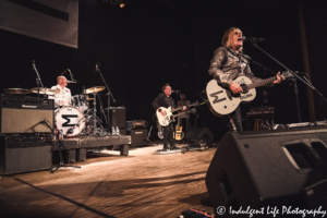 Lead singer Mike Peters of The Alarm performing with guitarist James Stevenson and drummer Steve Barnard at Liberty Hall in Lawrence, KS on August 10, 2019.