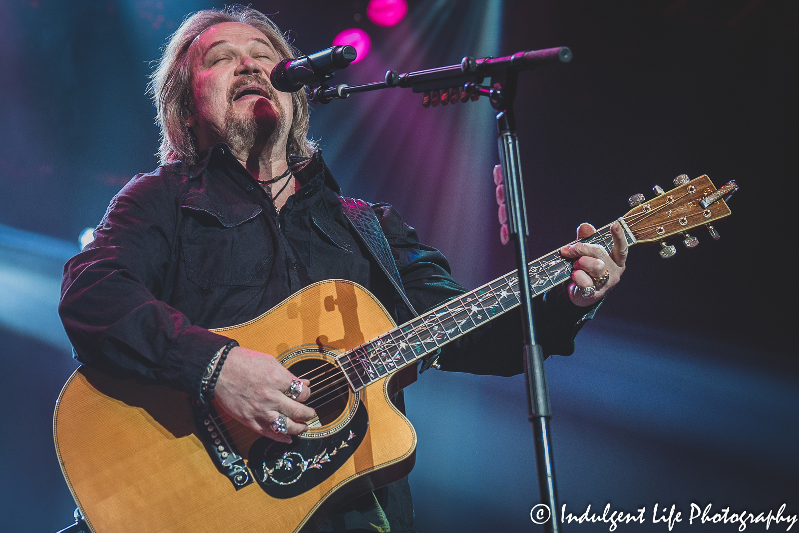 Country music superstar Travis Tritt playing the acoustic guitar as he performs "I'm Gonna Be Somebody" at Star Pavilion inside of Ameristar Casino in Kansas City, MO on December 3, 2021.