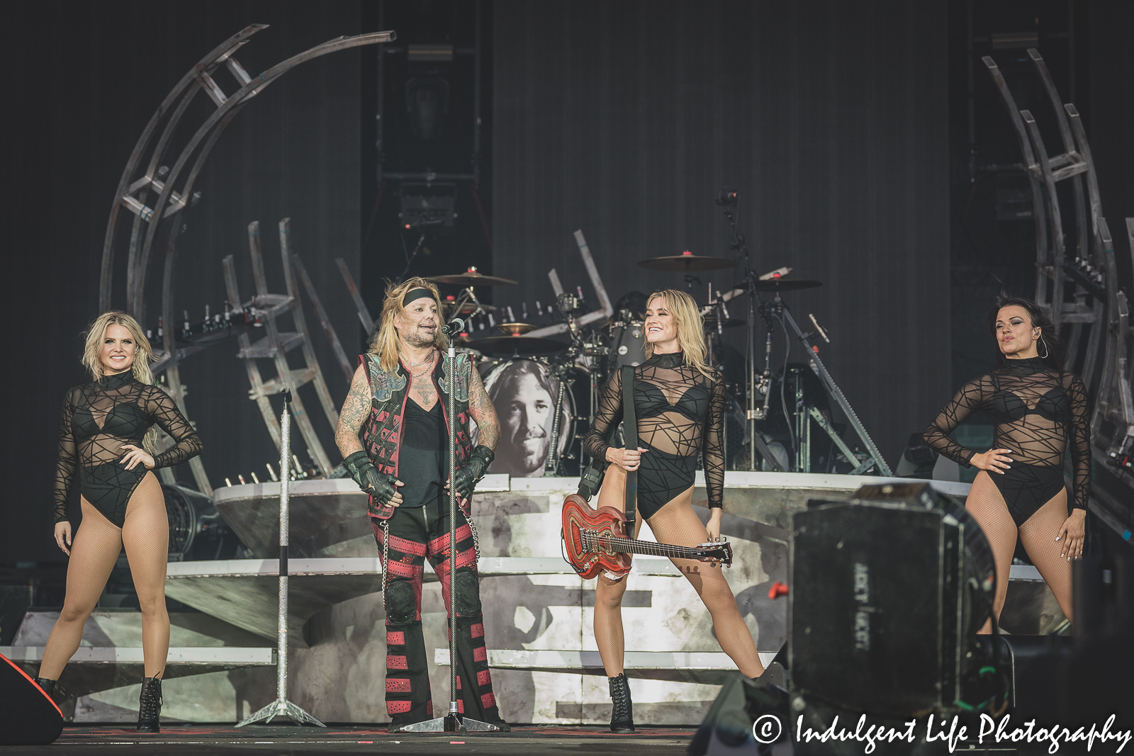 Frontman Vince Neil of Mötley Crüe showing off the dancers to the crowd during the band's concert at Kauffman Stadium in Kansas City, MO on July 19, 2022.