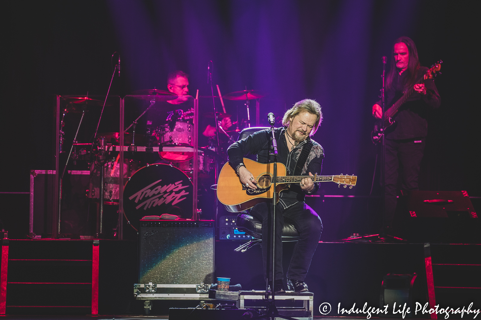 Travis Tritt performing live with his drummer and bass guitarist at Ameristar Casino Kansas City on December 10, 2022.