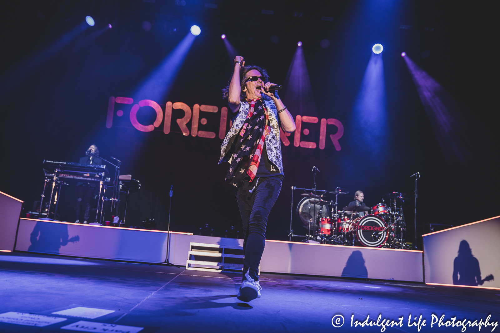 Foreigner lead singer Kelly Hansen performing "Head Games" with keyboard player Michael Bluestein and drummer Chris Frazier at Hartman Arena in Park City, KS on April 30, 2023.