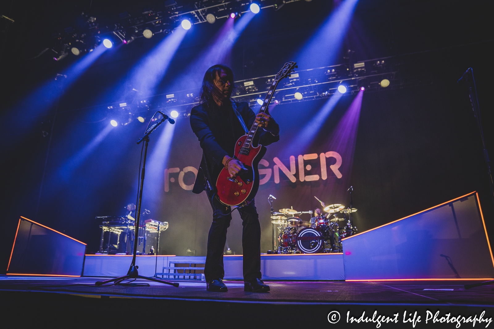 Foreigner guitarist Luis Maldonado performing live in concert with keyboard player Michael Bluestein and drummer Chris Frazier at Stormont Vail Events Center in Topeka, KS on May 2, 2023.