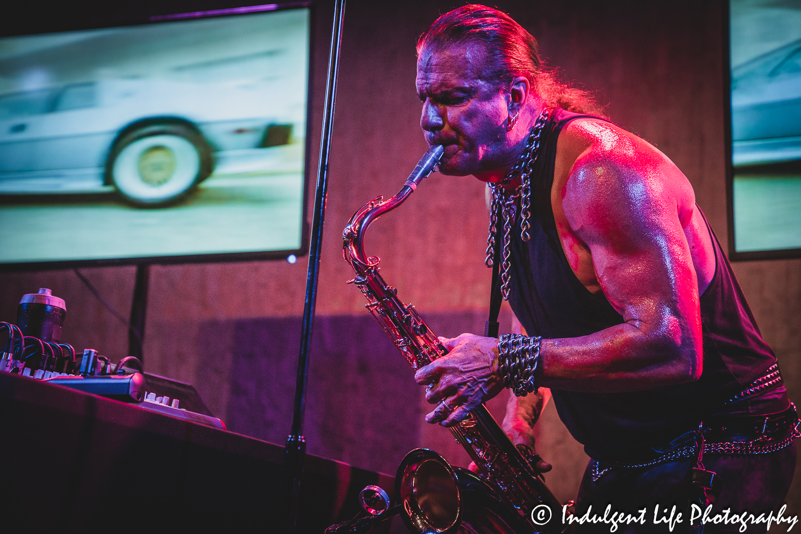 A "Miami Vice" clip playing behind Tim Cappello as he performs on the saxophone at the recordBar in Kansas City, MO on June 15, 2023.