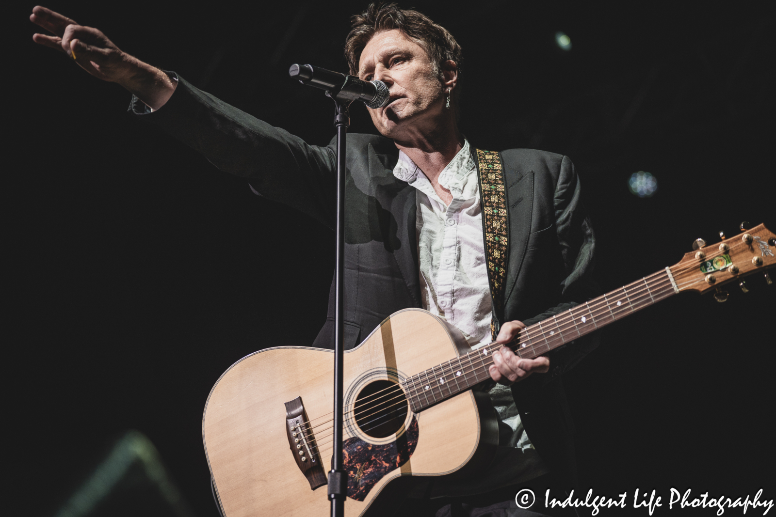 John Waite playing the acoustic guitar live during his "Missing You" 40th Anniversary concert at Ameristar Casino's Star Pavilion in Kansas City, MO on December 8, 2023.