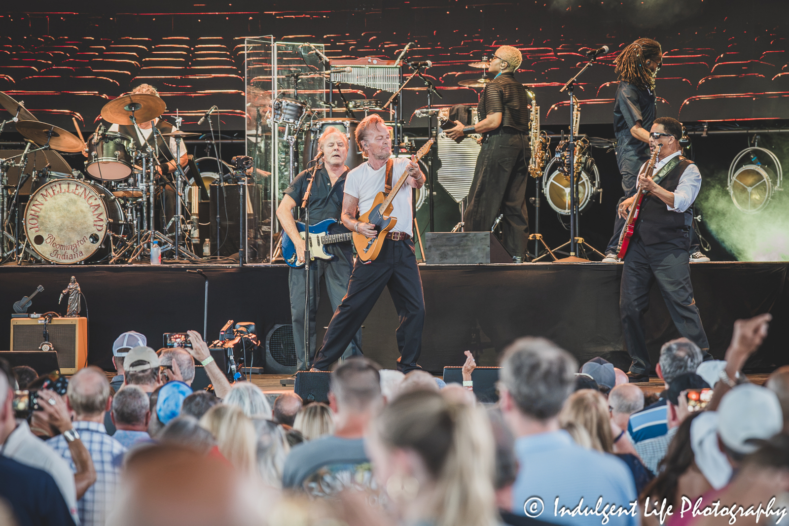 John Mellencamp playing the guitar and performing "Small Town" live in concert with his band John Mellencamp and his band live in concert performing "Lawless Times" at Morton Amphitheater in Riverside, MO on July 13, 2026.